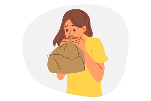 Woman experiences panic attack and breathing in paper bag, trying to recover from strong fright. Panic attack caused by psychological disorder causes inconvenience to girl, needs help psychotherapist