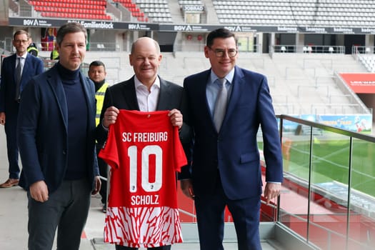 During his visit to Freiburg,Federal Chancellor Olaf Scholz receives a jersey from Jochen Saier (Board Member for Sport SC Freiburg),Oliver Leki (Chief Financial Officer SC Freiburg) and Lord Mayor Martin Horn on the right at the Europa Park Stadium Freiburg