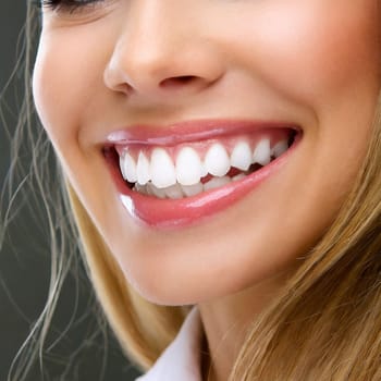 Dental health concept: woman smiling close up. Isolated on white.