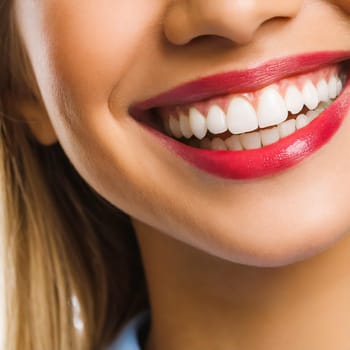 Dental health concept: woman smiling close up. Isolated on white.