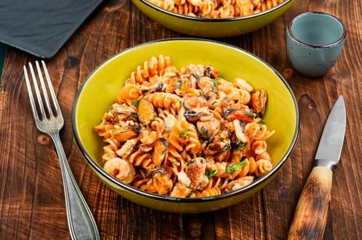 Mediterranean pasta or macaroni with seafood, pasta with mussels and shrimp on a plate.