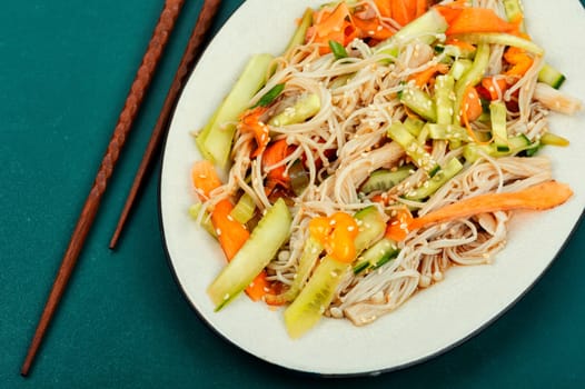 Vegan salad with enoki mushrooms, carrots, cucumber, fried sesame seeds. Healthy diet concept.
