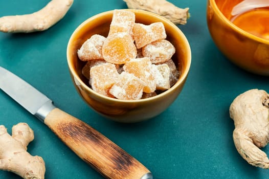 Dried candied ginger pieces and fresh rhizome root, candied ginger dessert.