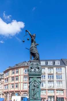 Frankfurt, Germany - September 30, 2022: statue of Lady Justice at the Roemer, the central place in Frankfurt with people visiting the landmark.