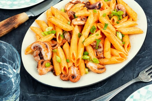Appetizing macaroni or pasta boiled with octopus. Pasta with seafood.