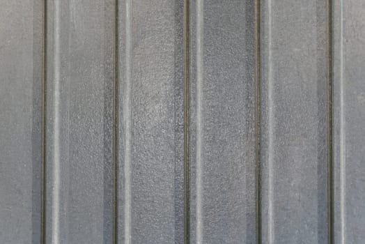 Background image of gray vertical metal plates with a glossy surface in close-up