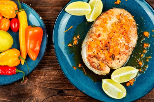 Grilled salmon or trout steak with orange and lime sauce. Space for text.