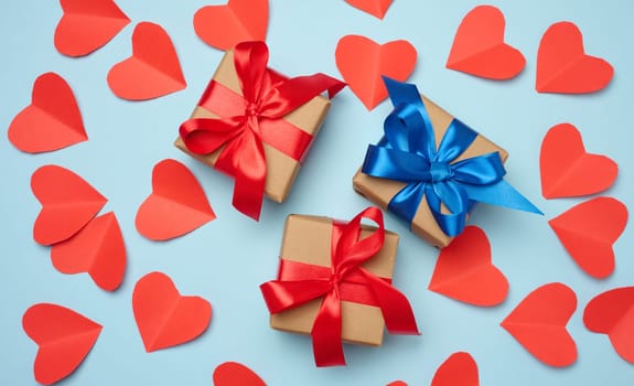 Gift box with red satin ribbon and bow on a blue background.Holiday background, flat lay