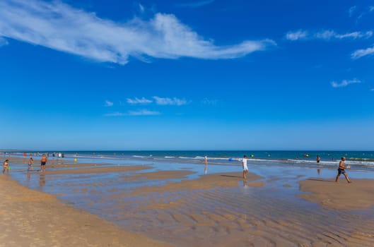 Tavira, Portugal - August 15, 2023: People at the famous beach of Tavira island in Tavira. This beach is a part of famous tourist region of Algarve.