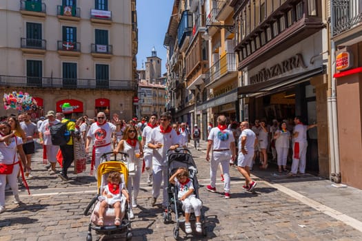 Pamplona, Spain: 09 July 2023: People celebrate San Fermin festival in traditional white abd red clothing with red necktie, Pamplona, Navarra, Spain.