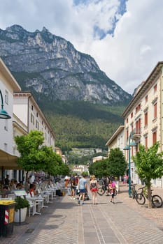 Pedestrian zone with stores and restaurants and orange trees in Riva del Garda on Lake Garda in Italy