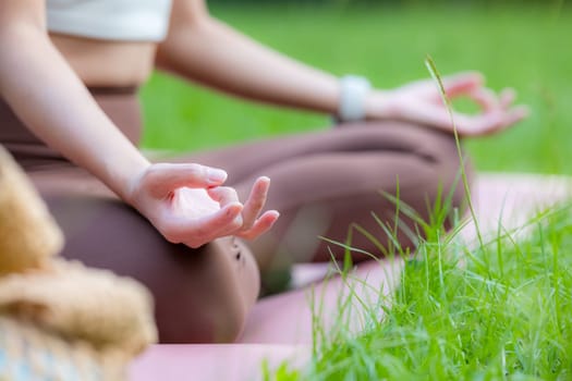 Woman practicing yoga lesson breathing meditating at outdoor park