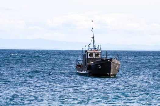 Fishermen in a motor boat sailing on Lake Baikal. Fishermen in a motor boat sailing on Lake Baikal.