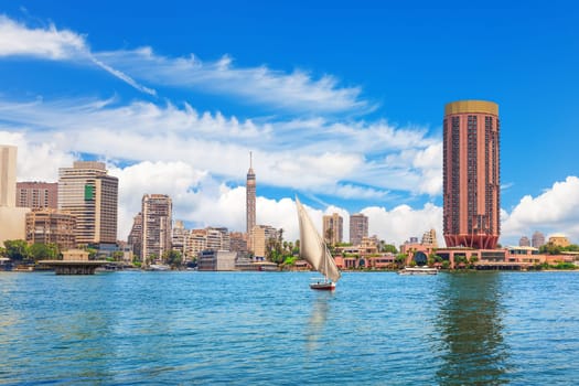 Typical sailboat in the Nile river and fancy buildings of Cairo, Egypt.