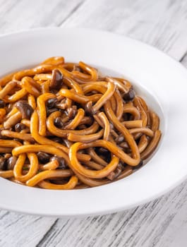 Portion of udon noodles with brown beach mushrooms