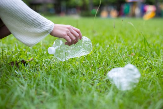 Woman take away the water bottle trash at park
