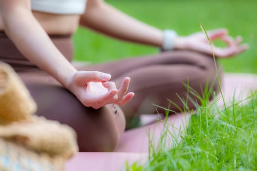 Woman practicing yoga lesson breathing meditating at outdoor park