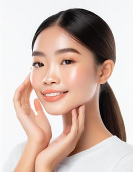 Skin care. Woman with beauty face touching healthy facial skin portrait. Beautiful smiling asian girl model with natural makeup touching glowing hydrated skin on blue background closeup