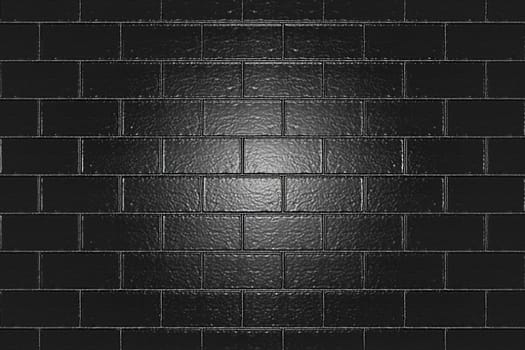 A rough glossy black brick wall with a backlight in the center. Texture or background