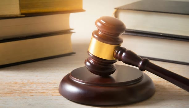 Wooden gavel and books on wooden table, law concept