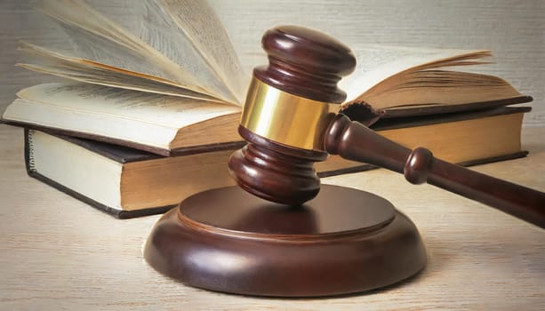 Wooden gavel and books on wooden table, law concept