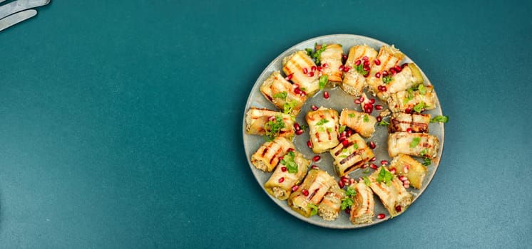 Fried eggplant rolls with walnut, garlic filling and decorated with pomegranate. Badrijani