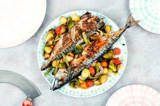Plate with roasted mackerel or scomber fish and tomatoes, cabbage and green beans