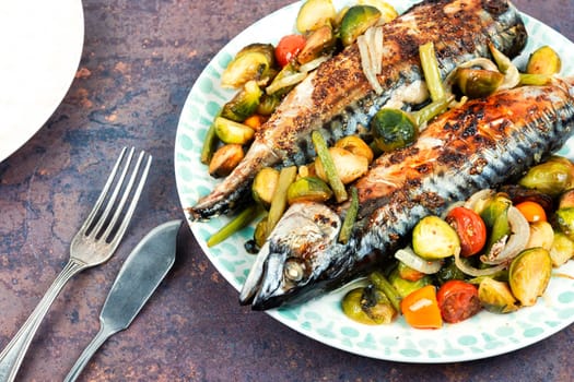 Plate with roasted mackerel or scomber fish and tomatoes, cabbage and green beans