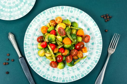 Salad of roasted brussels sprouts, tomatoes and green beans. Healthy vegan food concept. Flat lay with copy space