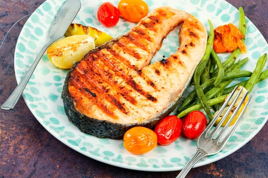 Grilled salmon steak with grilled vegetables, fried fish. Space for text.