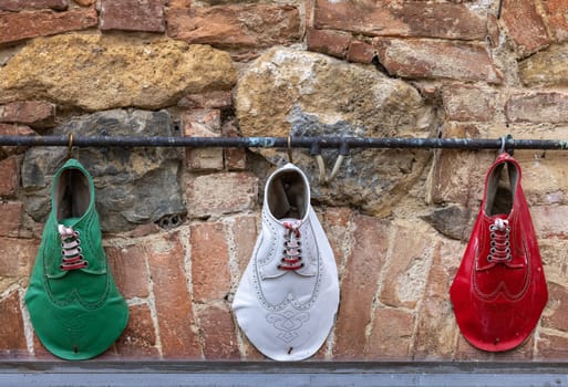 Monteriggioni, Italy - Sept 17, 2022: Decoration of a shoe store in a retro atmosphere and national colors of Italy in Monteriggioni. Tuscany.