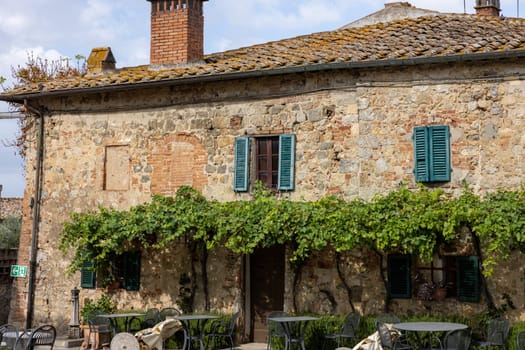 Monteriggioni, Italy - Sept 17, 2022: Restaurant in Piazza Roma in Monteriggioni medieval walled town near Siena in Tuscany, Italy