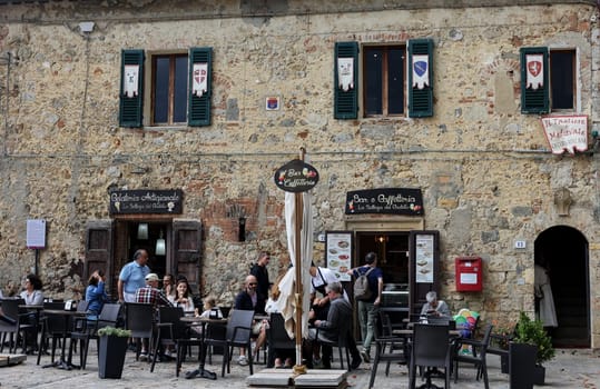 Monteriggioni, Italy - Sept 17, 2022: Restaurant in Piazza Roma in Monteriggioni medieval walled town near Siena in Tuscany, Italy