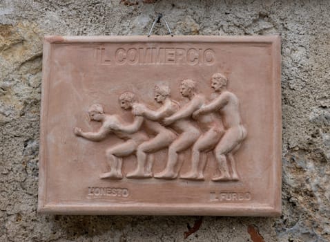 Monteriggioni, Italy - Sep 17, 2022: Ceramics decoration hanging on the wall of a house in Monteriggioni medieval walled town near Siena in Tuscany, Italy