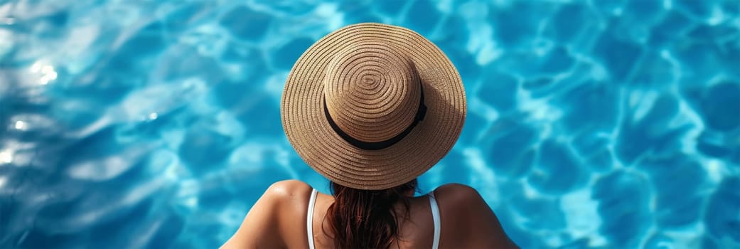 A woman wearing a straw hat sits by a sparkling pool, representing relaxation and tranquility. Copy space available. travel and leisure content