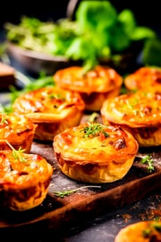 Close-up of savory tartlets with a focus on the melted cheese and herb topping.