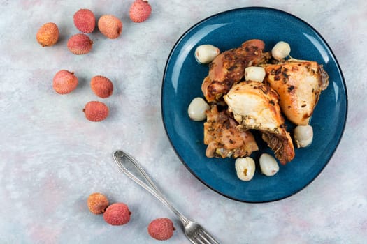 Pieces of grilled or smoked chicken meat with lychee on a plate.