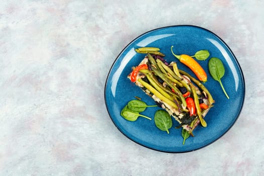 Piece vegetable homemade pie with green or bush beans and peppers on rustic wooden background.