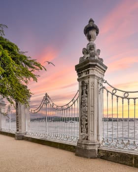 Ornate wrought iron fence decorated with intricate designs at the Dolmabahce Palace overlooking the Bosphorus Strait in Istanbul, Turkey after sunrise