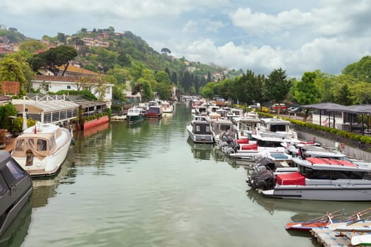 Group of different shapes, sizes and colors boats docked in Goksu Stream, beside Anadolu Hisari historic castle on the Asian side of the Bosphorus in Istanbul, Turkey