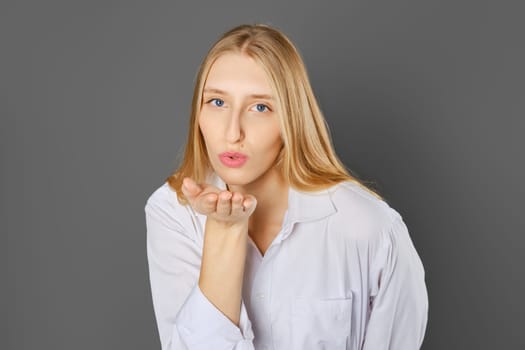 Top view of cute blonde woman blowing a kiss