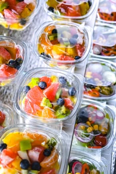 Plastic boxes with pre-packaged fruit salads, put up for sale in a commercial refrigerator