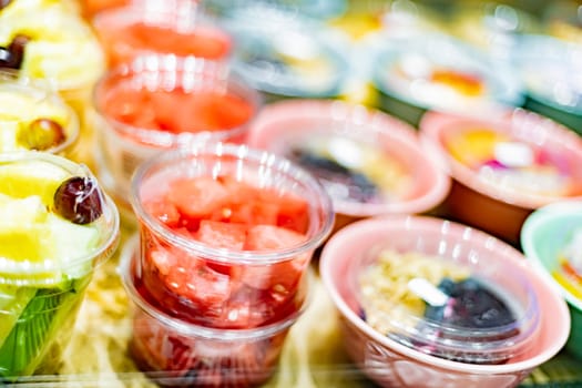 Pre-packaged fruit salads displayed in a commercial refrigerator
