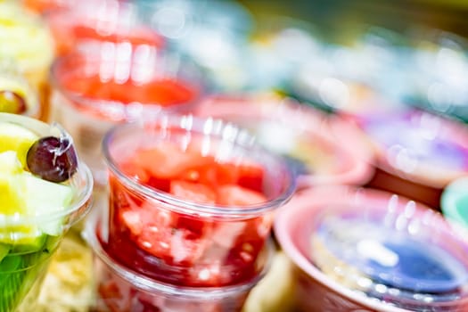 Pre-packaged fruit salads displayed in a commercial refrigerator