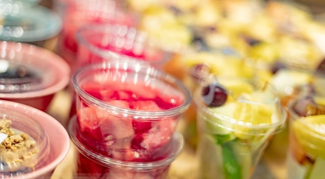 Pre-packaged fruit salads displayed in a commercial refrigerator