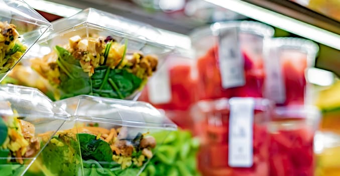 Pre-packaged ready to eat meals and fruit salads displayed in a commercial refrigerator