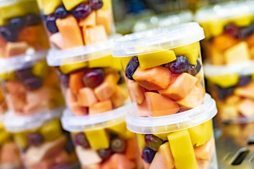 Pre-packaged fruit salads displayed in a commercial refrigerator