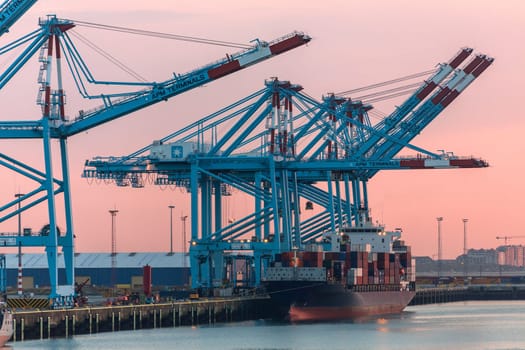 Ship in dock at sunset in the Port of Zeebrugge in Belgium. The port is a large container, bulk cargo, new vehicle and passenger ferry terminal handling over 50 million tonnes of cargo annually.
