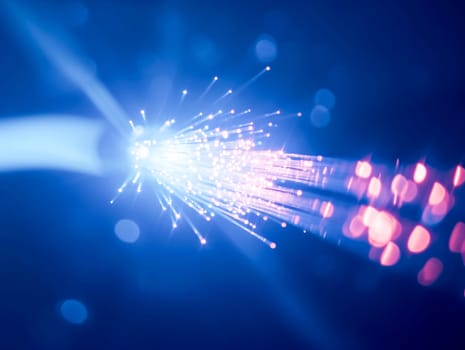 Macro image of a fiber optic cable emitting blue light particles , representing high-speed data transfer.Tech industry advertisements, internet service promotions