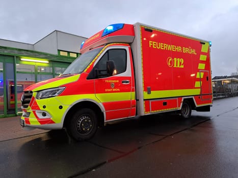 Rettungswagen der Feuerwehr mit Blaulicht bei einem Einsatz, Nordrhein-Westfalen, Deutschland, Brühl